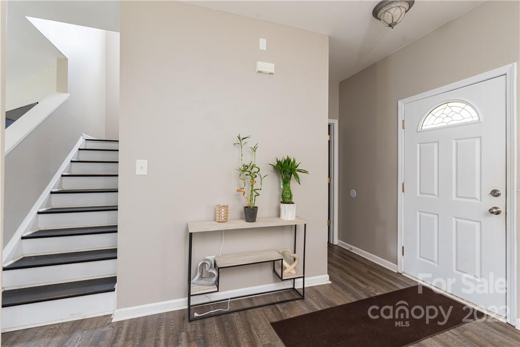 11429 Chapeclane Road Charlotte, NC 28278 - Photo 3 of 26 a view of a hallway with wooden floor and a potted plant