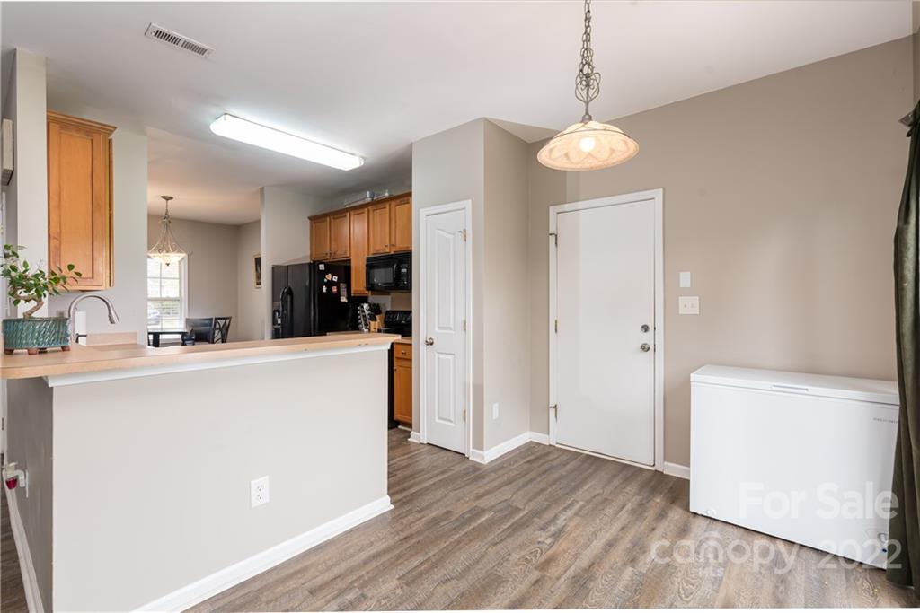 11429 Chapeclane Road Charlotte, NC 28278 - Photo 7 of 26 a view of kitchen with refrigerator a microwave and wooden floor