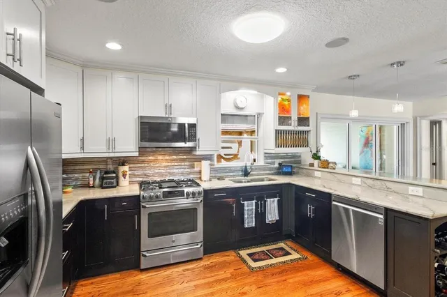 a kitchen with stainless steel appliances granite countertop a stove a sink and a refrigerator