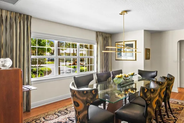 a dining room with furniture a chandelier and wooden floor