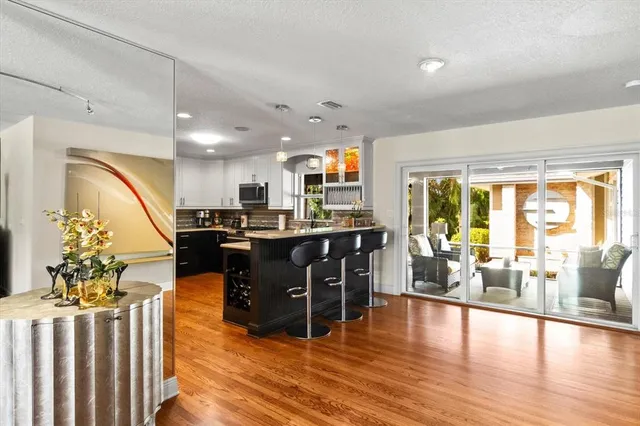 a living room with furniture large window and wooden floor