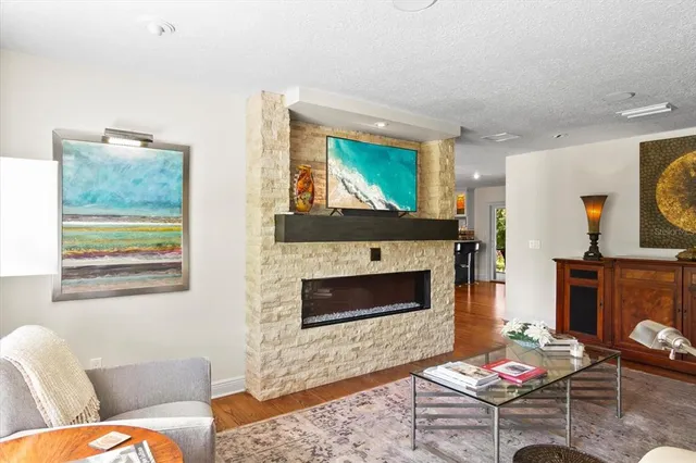 a living room with furniture a flat screen tv and a fireplace