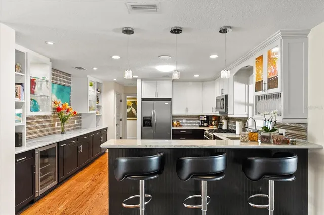 a kitchen with stainless steel appliances kitchen island granite countertop a stove a sink and a refrigerator