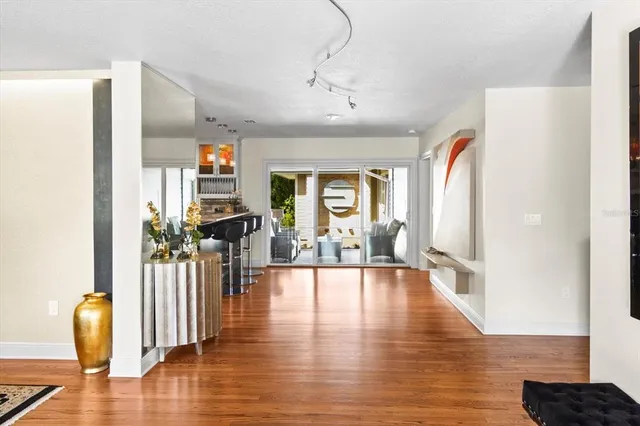 a view of a living room with wooden floor and windows