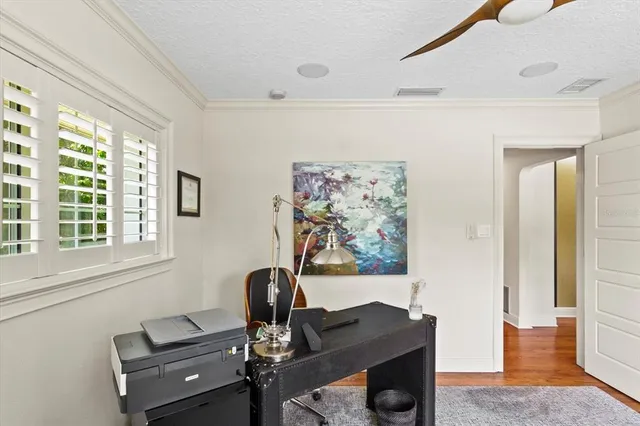 a view of a workspace with furniture and a window