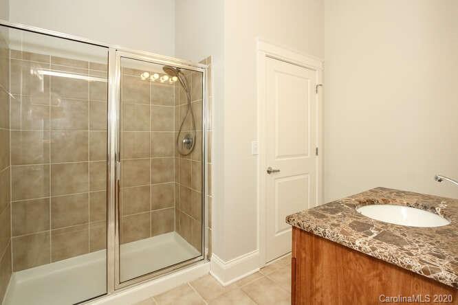 1700 Camden Road, Unit 201 Charlotte, NC 28203 - Photo 14 of 30 a bathroom with a granite countertop shower and a sink