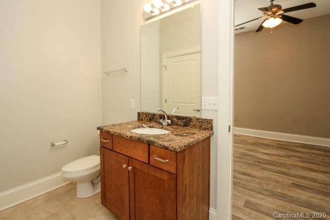 1700 Camden Road, Unit 201 Charlotte, NC 28203 - Photo 15 of 30 a bathroom with a granite countertop sink a toilet and a mirror