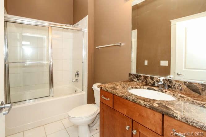 1700 Camden Road, Unit 201 Charlotte, NC 28203 - Photo 20 of 30 a bathroom with a granite countertop sink toilet and shower