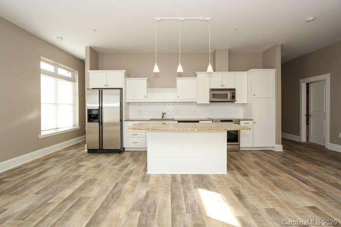 1700 Camden Road, Unit 201 Charlotte, NC 28203 - Photo 5 of 30 a large kitchen with cabinets wooden floor and a window