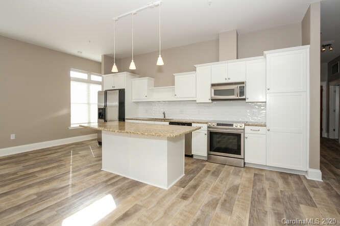 1700 Camden Road, Unit 201 Charlotte, NC 28203 - Photo 6 of 30 a kitchen with kitchen island a stove a sink and a refrigerator