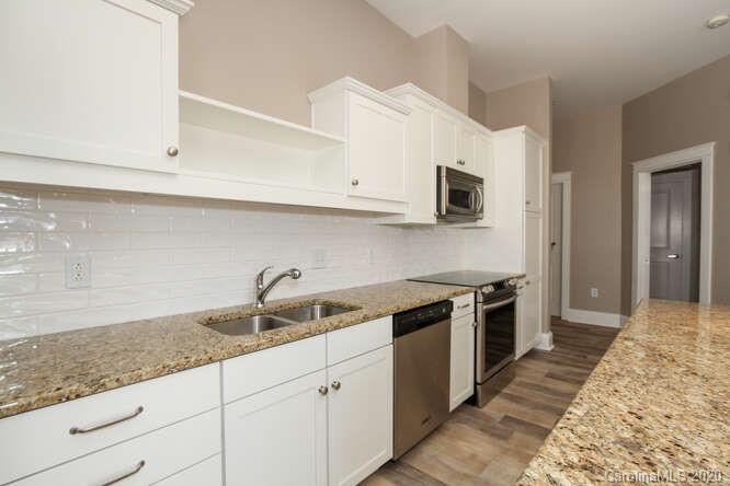 1700 Camden Road, Unit 201 Charlotte, NC 28203 - Photo 7 of 30 a kitchen with granite countertop a sink and a stove