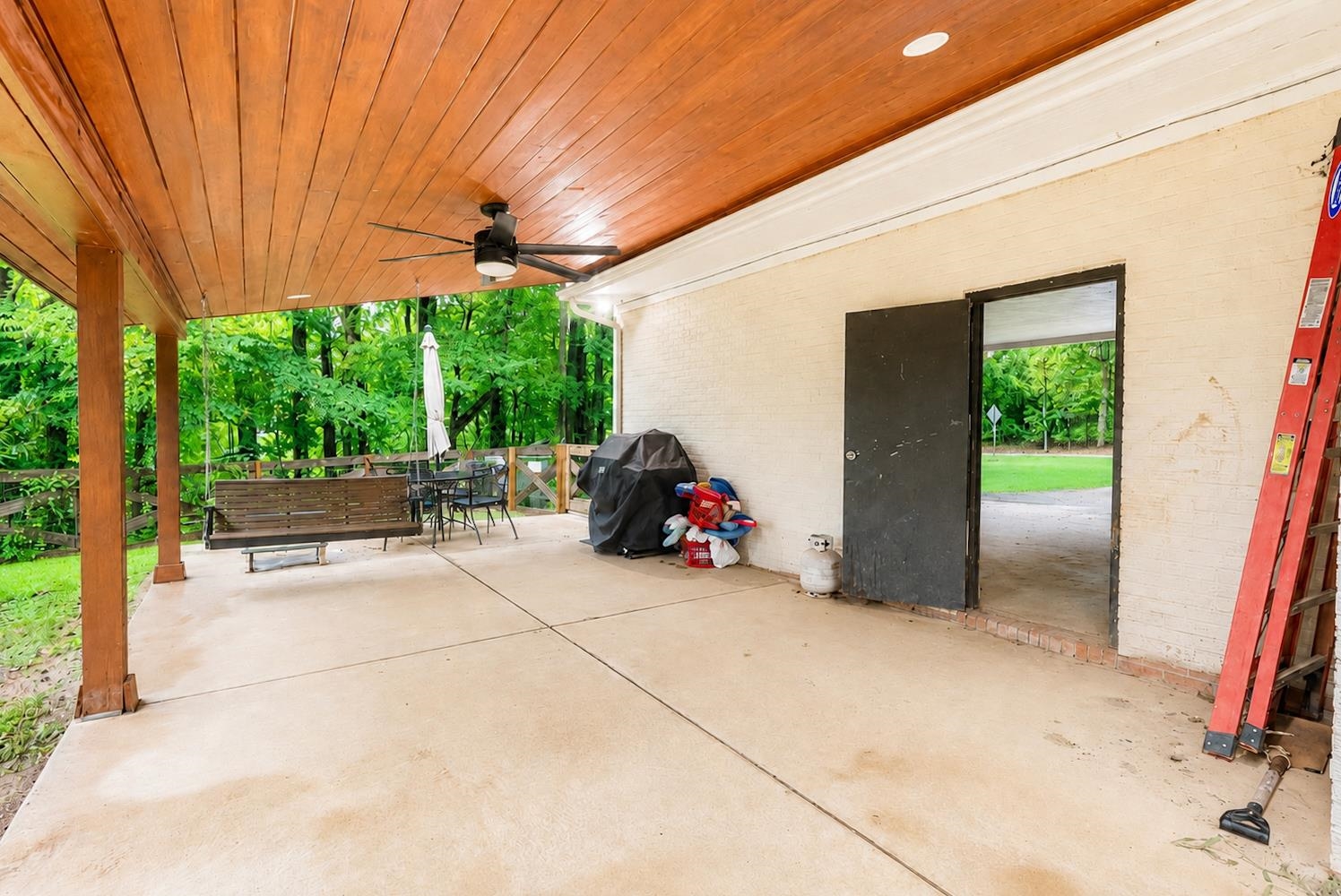 10093 Mt Carmel Road Brighton, TN 38011 - Photo 5 of 36 Expansive covered patio featuring a wood-panel ceiling, dark-tone ceiling fan, and concrete flooring