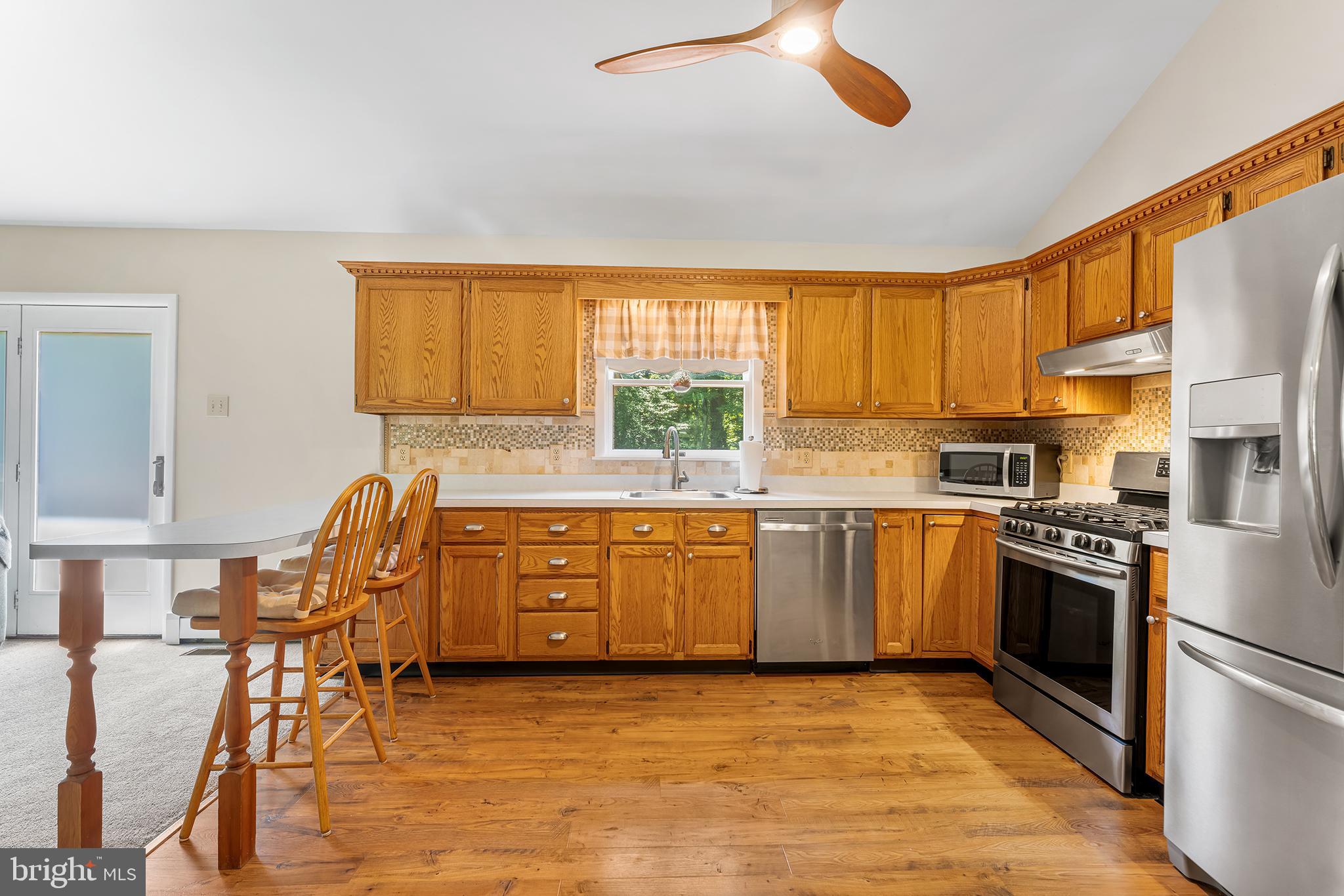 1431 Burleigh Road Cape May Court House, NJ 08210 - Photo 13 of 35 a kitchen with stainless steel appliances granite countertop a stove top oven a sink a dining table and chairs