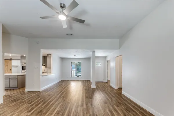 an empty room with windows fireplace and a sink