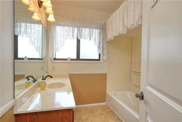a bathroom with a tub sink and window
