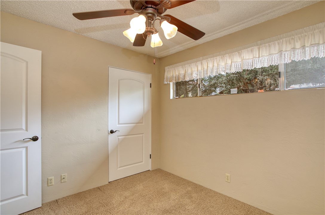 910 North 12th Street Grover Beach, CA 93433 - Photo 22 of 42 an empty room with a chandelier fan and windows