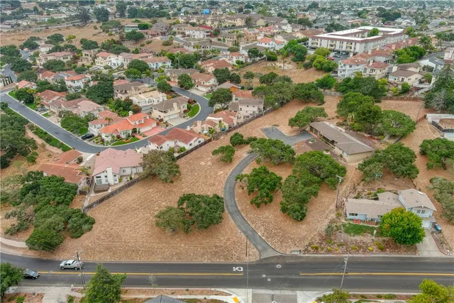 an aerial view of residential houses with outdoor space and parking