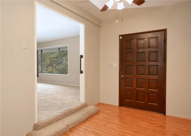 an empty room with closet and a chandelier fan
