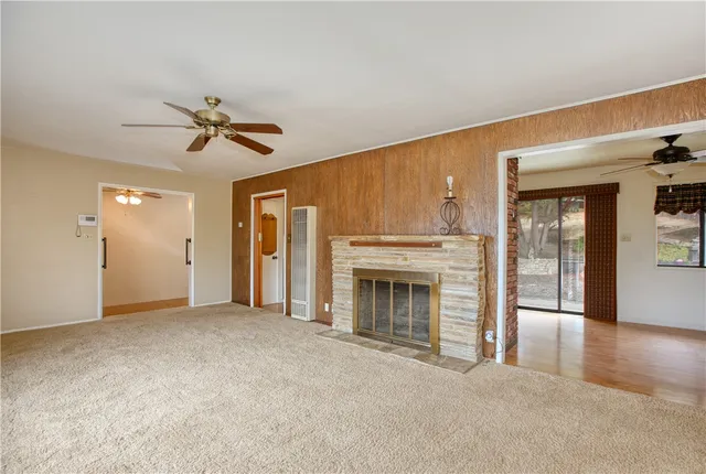 a view of empty room with a fireplace and fan