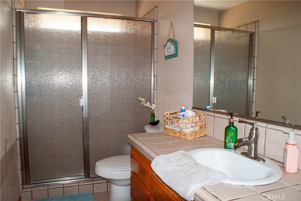 8465 Cedar Court Phelan, CA 92371 - Photo 21 of 51 a bathroom with a granite countertop sink toilet and shower