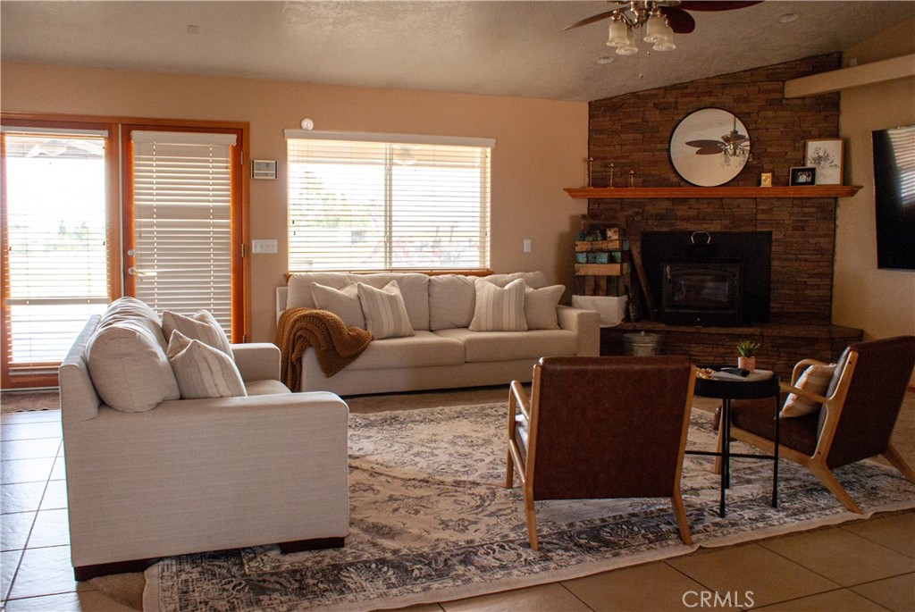8465 Cedar Court Phelan, CA 92371 - Photo 22 of 51 a living room with furniture a large window and a fireplace