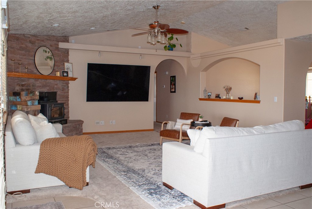 8465 Cedar Court Phelan, CA 92371 - Photo 24 of 51 a living room with furniture a fireplace and a flat screen tv