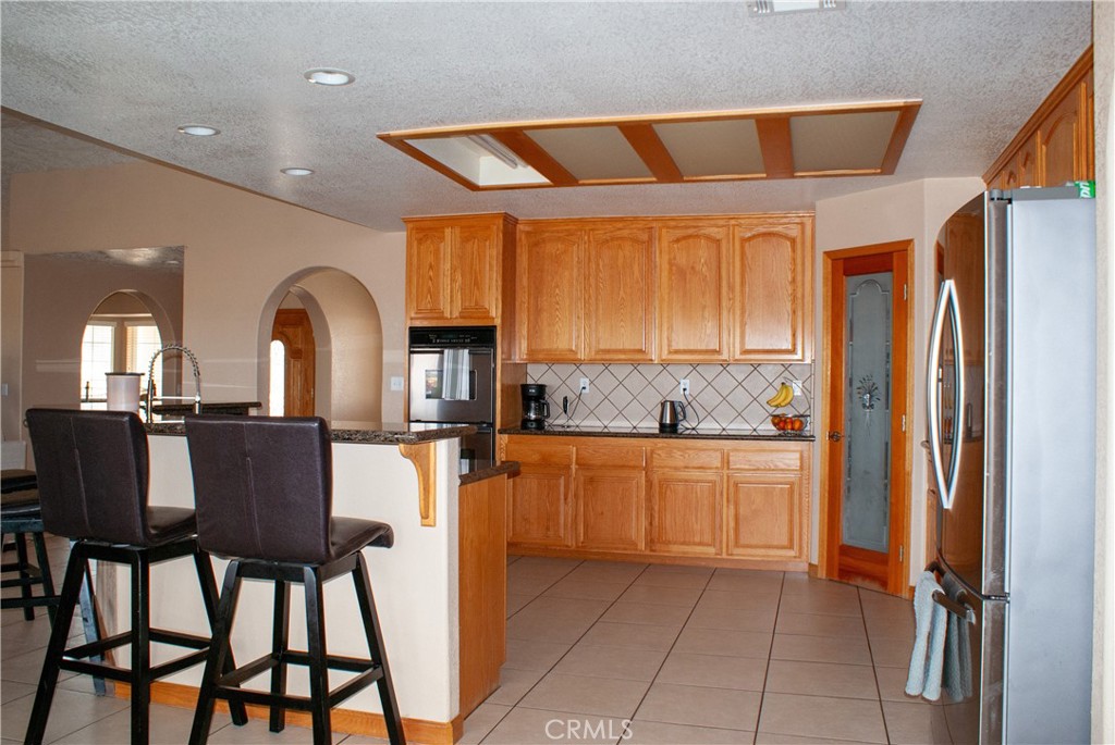 8465 Cedar Court Phelan, CA 92371 - Photo 32 of 51 a kitchen with stainless steel appliances granite countertop a refrigerator and microwave