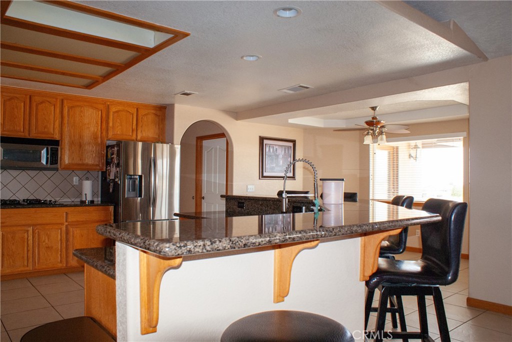 8465 Cedar Court Phelan, CA 92371 - Photo 35 of 51 a dining hall with stainless steel appliances granite countertop a dining table and chairs with wooden floor