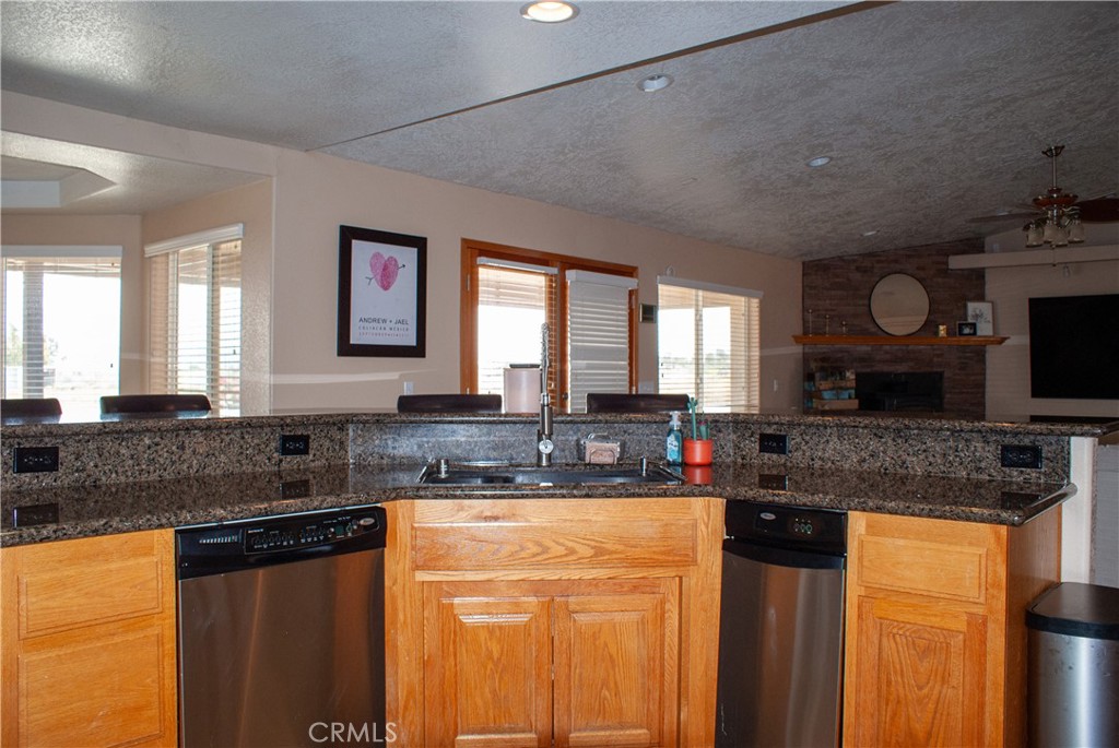 8465 Cedar Court Phelan, CA 92371 - Photo 40 of 51 a kitchen with granite countertop a sink a stove top oven a counter space and cabinets