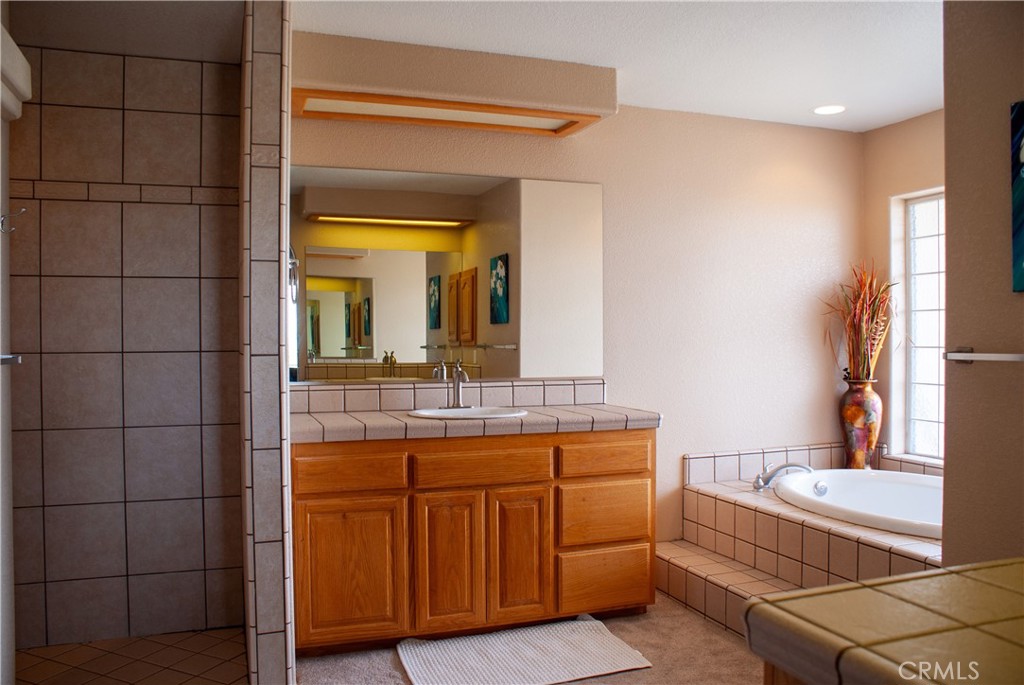 8465 Cedar Court Phelan, CA 92371 - Photo 47 of 51 a bathroom with a granite countertop sink a mirror and a bathtub