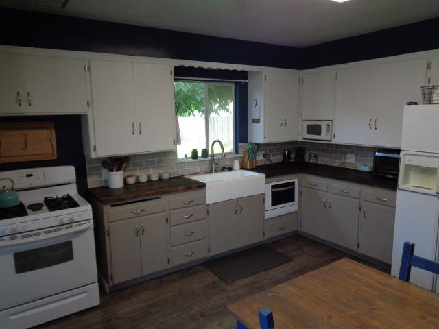 1061 Cyrier Avenue Reedley, CA 93654 - Photo 4 of 13 a kitchen with granite countertop white cabinets and white appliances