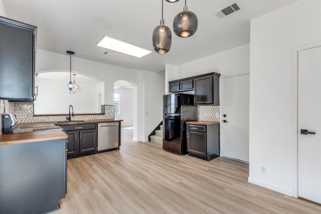 9204 Magna Carta Loop Austin, TX 78754 - Photo 12 of 27 Kitchen featuring tasteful backsplash, arched walkways, butcher block countertops, and decorative light fixtures