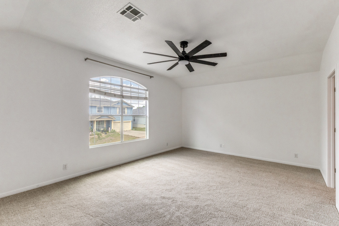 9204 Magna Carta Loop Austin, TX 78754 - Photo 18 of 27 Empty room featuring light colored carpet, ceiling fan, and lofted ceiling