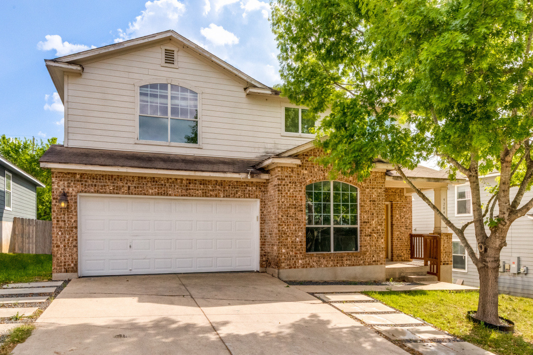 9204 Magna Carta Loop Austin, TX 78754 - Photo 2 of 27 Traditional-style home featuring brick siding, driveway, and an attached garage