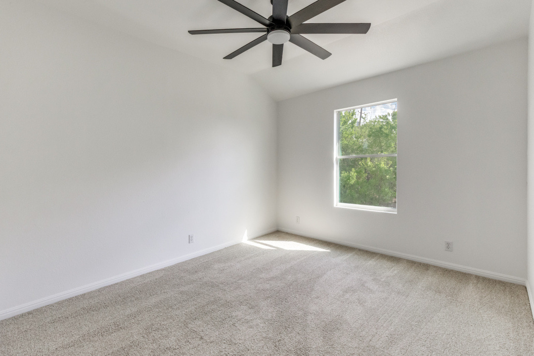 9204 Magna Carta Loop Austin, TX 78754 - Photo 21 of 27 Carpeted spare room featuring ceiling fan and lofted ceiling