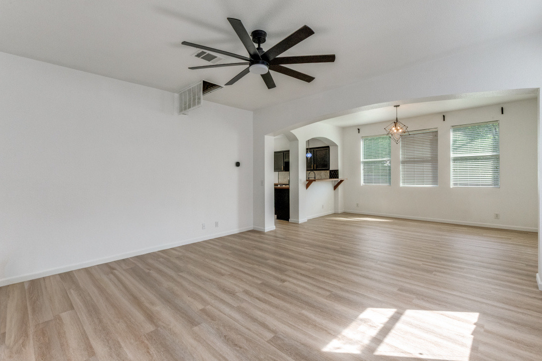 9204 Magna Carta Loop Austin, TX 78754 - Photo 5 of 27 Unfurnished living room featuring light wood-style floors, a ceiling fan, and arched walkways