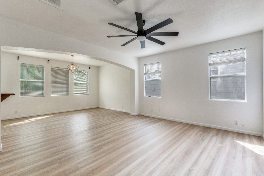 9204 Magna Carta Loop Austin, TX 78754 - Photo 6 of 27 Unfurnished room featuring light wood-style floors, a ceiling fan, plenty of natural light, and arched walkways