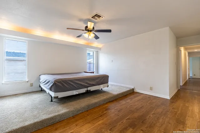 a bedroom with a bed and wooden floor