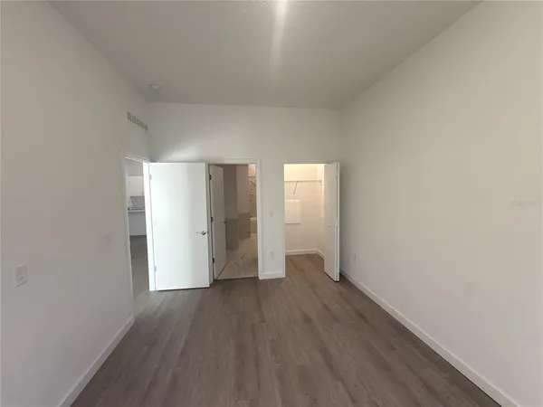 a view of empty room with wooden floor