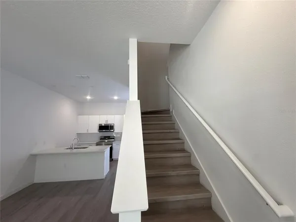 a view of entryway and kitchen with wooden floor