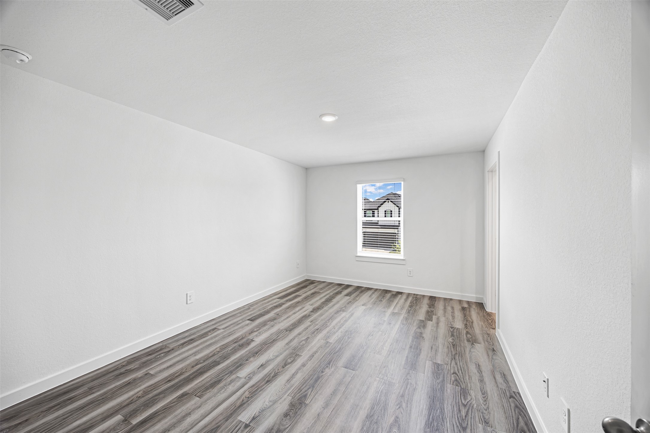 12305 Brandenburg Gate Road Houston, TX 77047 - Photo 9 of 22 an empty room with wooden floor and windows