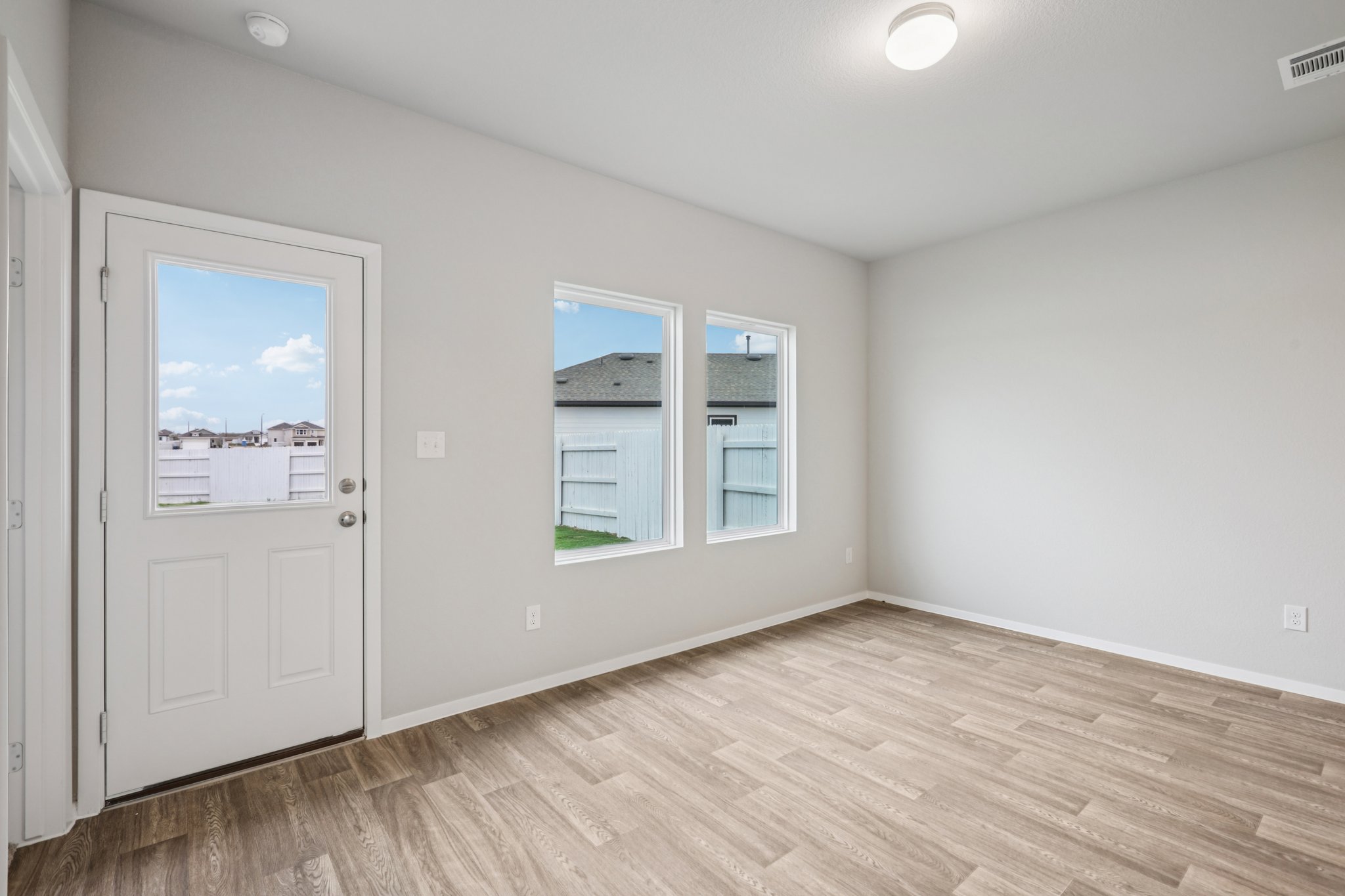 104 Summer Drive Elgin, TX 78621 - Photo 15 of 40 an empty room with wooden floor and windows