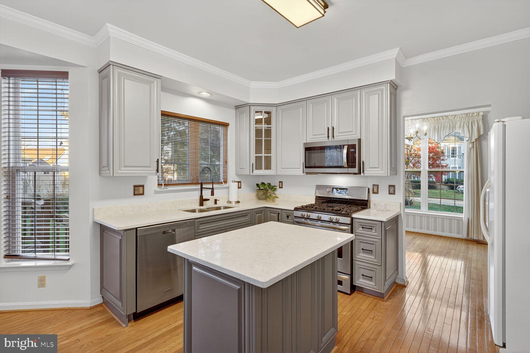8205 Swamp Rose Place Laurel, MD 20724 - Photo 6 of 34 a kitchen with a stove a sink and a microwave