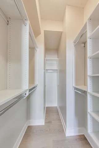 a view of walk in closet with empty racks