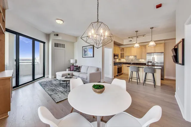 a dining room with furniture a chandelier and wooden floor