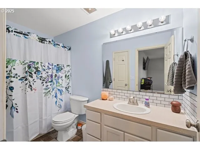 a bathroom with a sink vanity mirror and toilet
