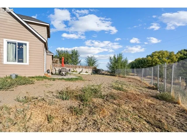 a view of a yard with wooden fence