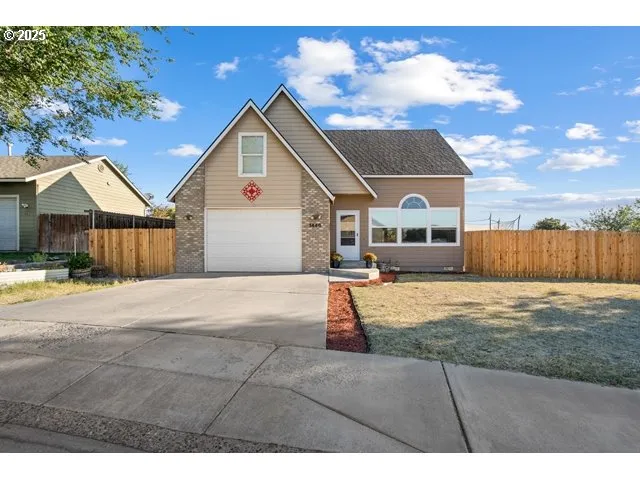 a view of a house with a yard and wooden fence