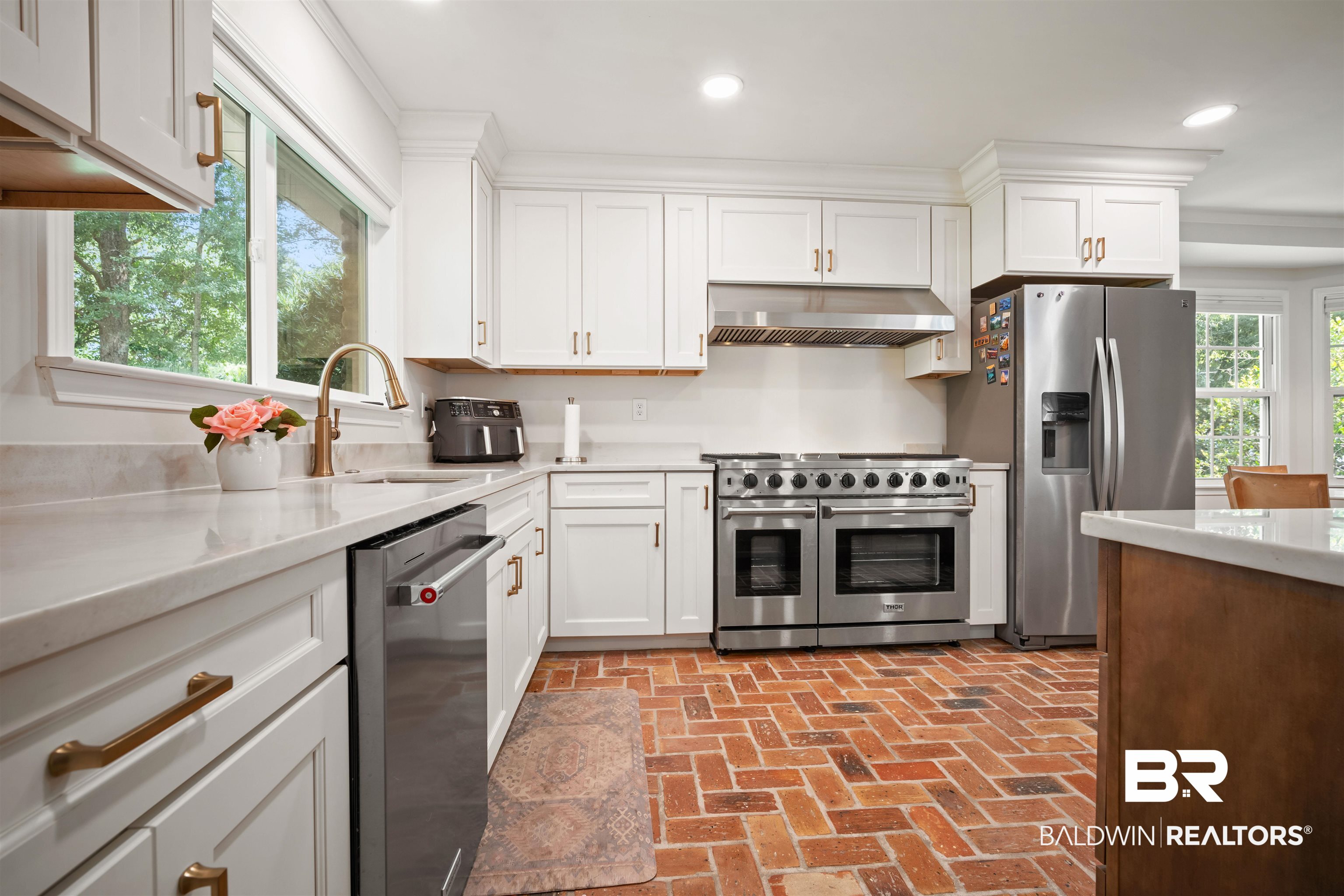 700 Eliza Jordan Road North Mobile, AL 36608 - Photo 2 of 44 Kitchen with appliances with stainless steel finishes, brick floors, white cabinets, extractor fan, and light stone countertops