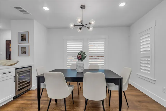 a large kitchen with kitchen island a dining table chairs and a wooden floor